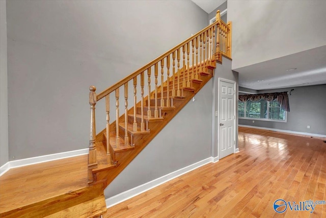 stairway featuring a high ceiling and wood-type flooring