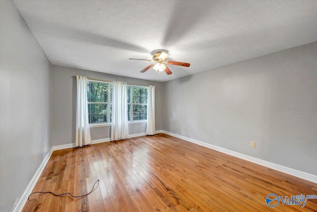 spare room with ceiling fan, wood-type flooring, and a textured ceiling