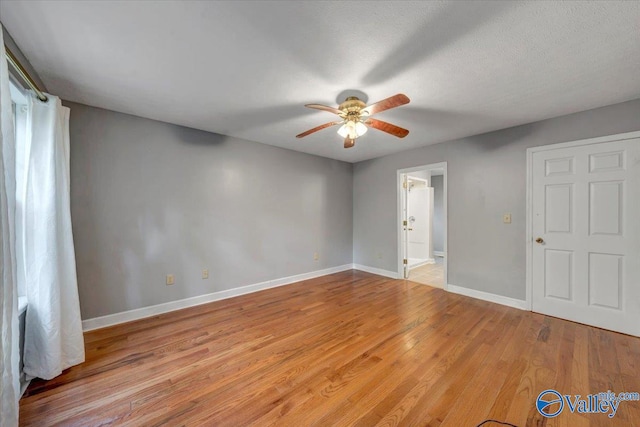 unfurnished room featuring a textured ceiling, light wood-type flooring, and ceiling fan