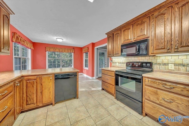 kitchen with black appliances, light tile patterned flooring, and tasteful backsplash