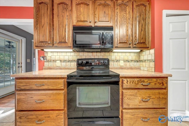 kitchen with light hardwood / wood-style floors, black appliances, and backsplash