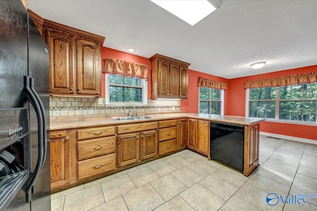 kitchen with decorative backsplash, black appliances, sink, and light tile patterned floors