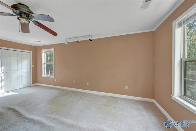 unfurnished bedroom featuring light carpet, crown molding, a closet, and ceiling fan