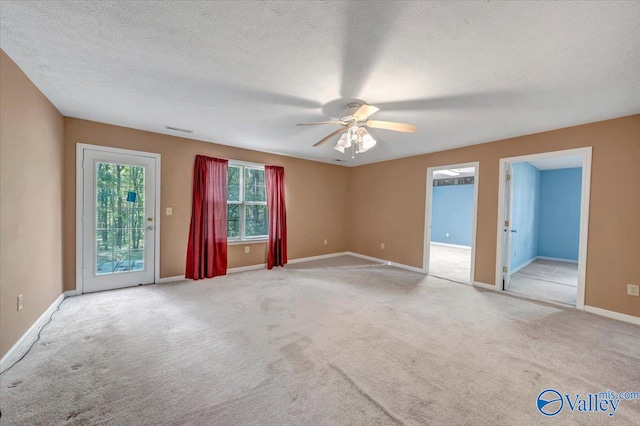 spare room featuring a textured ceiling, light colored carpet, and ceiling fan