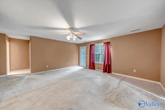 unfurnished room with carpet, ceiling fan, and a textured ceiling