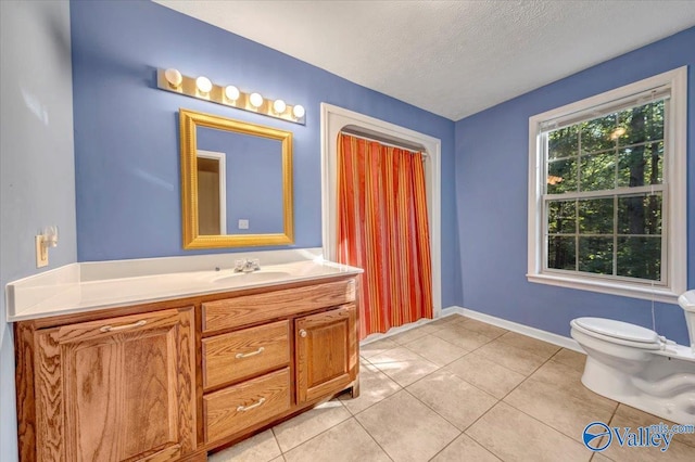 bathroom with vanity, a textured ceiling, toilet, and tile patterned flooring