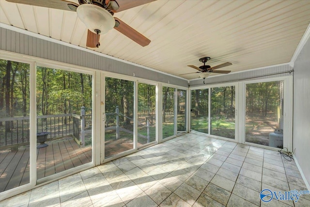 unfurnished sunroom with a healthy amount of sunlight, wooden ceiling, and ceiling fan