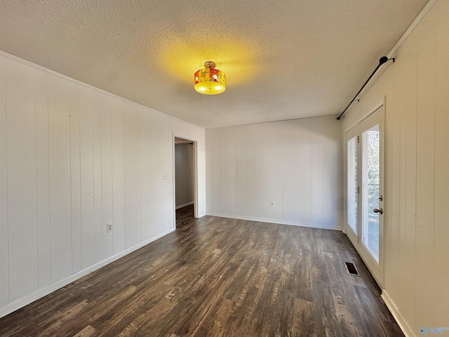 unfurnished room with dark wood-type flooring and a textured ceiling