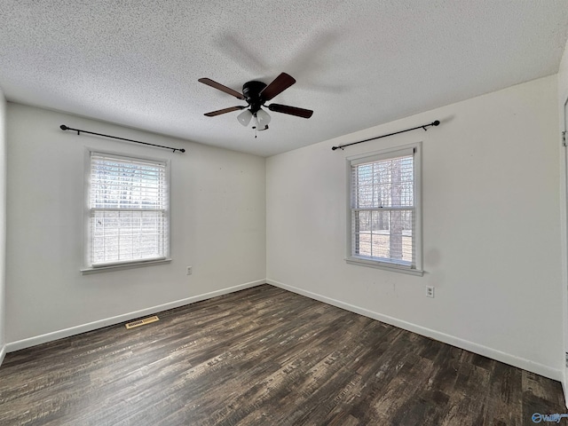 empty room with ceiling fan, a textured ceiling, and dark hardwood / wood-style flooring