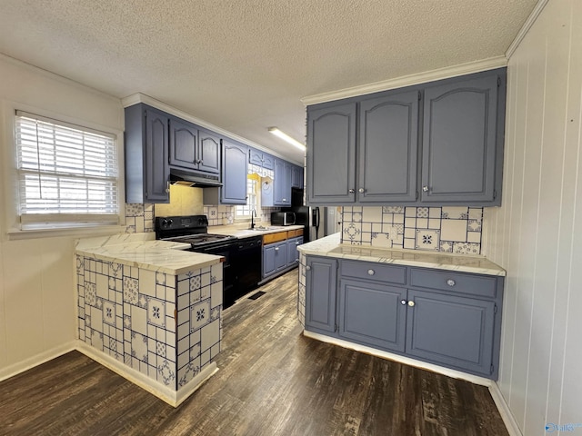 kitchen with dark hardwood / wood-style floors, a textured ceiling, and black appliances