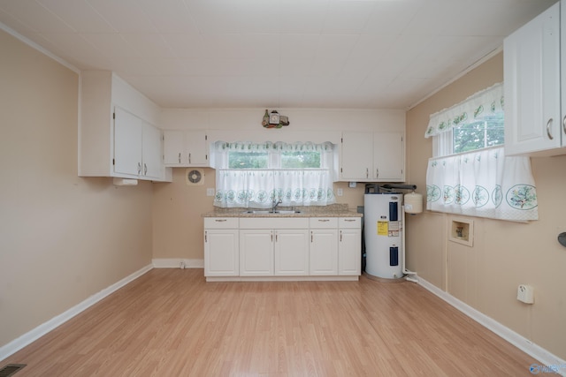 2116 Virginia Blvd NW, Huntsville, AL 35811 - kitchen featuring electric water heater, light wood-style flooring, white cabinets, and plenty of natural light