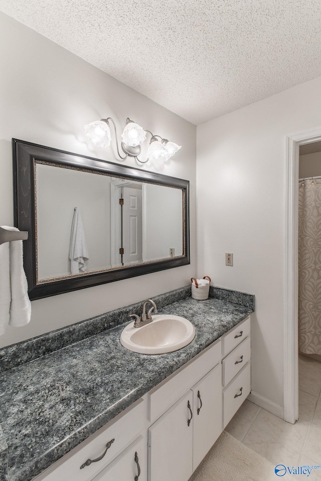 bathroom featuring vanity, tile patterned flooring, and a textured ceiling