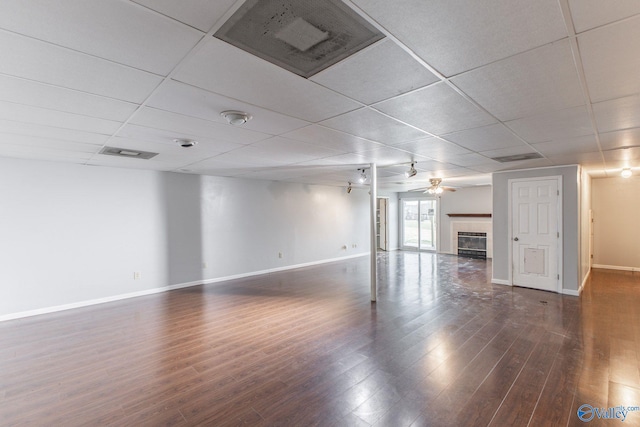 interior space featuring visible vents, a ceiling fan, dark wood-style floors, a paneled ceiling, and a tile fireplace