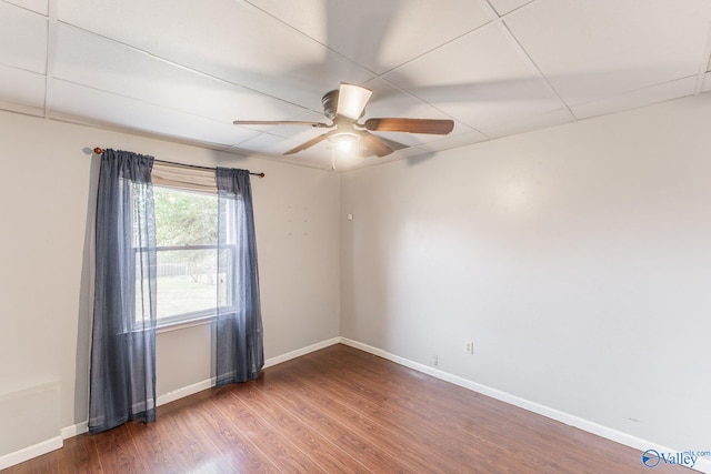 empty room featuring ceiling fan, baseboards, and wood finished floors