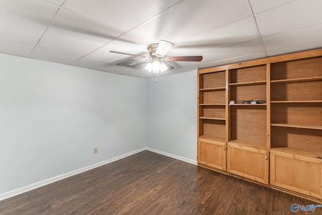 unfurnished room featuring a paneled ceiling, baseboards, dark wood-type flooring, and ceiling fan