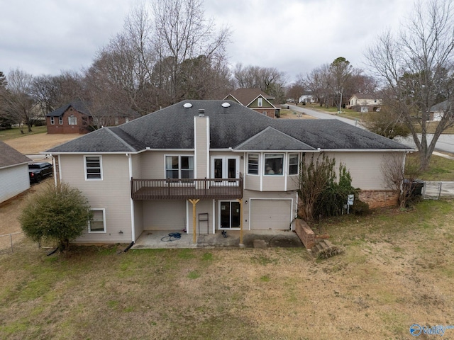 back of property featuring a lawn, a chimney, a garage, driveway, and a patio