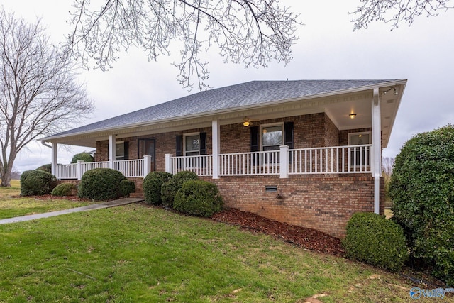 single story home with brick siding, a porch, a front lawn, and a shingled roof