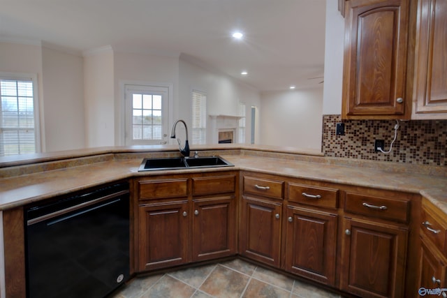 kitchen with decorative backsplash, crown molding, a sink, light countertops, and black dishwasher