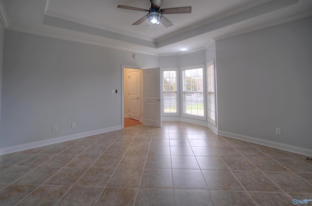 tiled spare room featuring crown molding, a ceiling fan, baseboards, and a tray ceiling