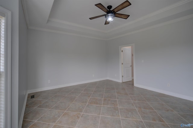 spare room with tile patterned flooring, ornamental molding, ceiling fan, visible vents, and a tray ceiling