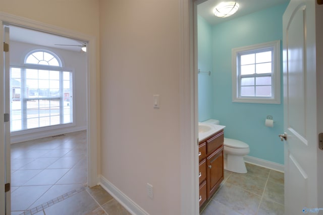 bathroom featuring baseboards, toilet, tile patterned flooring, and vanity