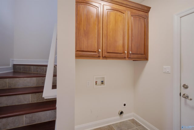 laundry room with electric dryer hookup, washer hookup, cabinet space, and baseboards