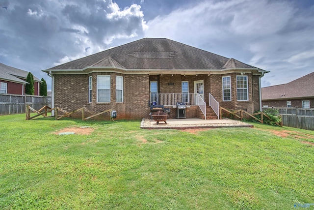 back of house featuring a patio, a yard, a fenced backyard, and brick siding