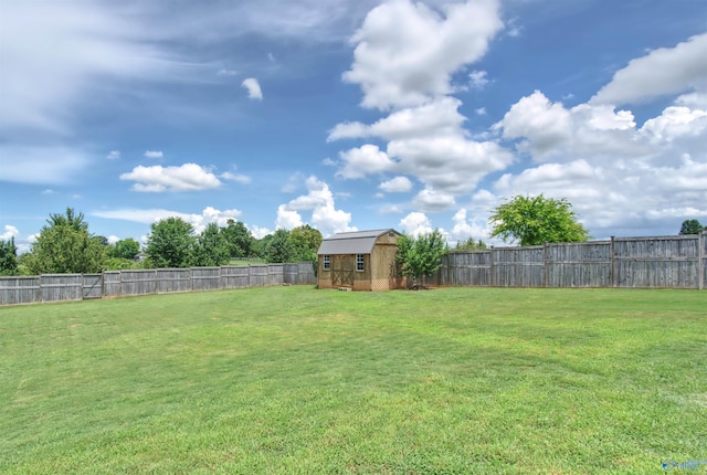 view of yard featuring an outdoor structure, a fenced backyard, and a storage shed