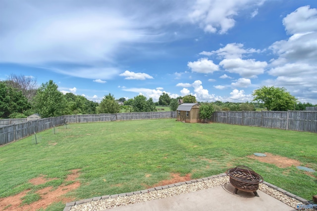 view of yard featuring a storage shed, an outdoor fire pit, an outdoor structure, and a fenced backyard