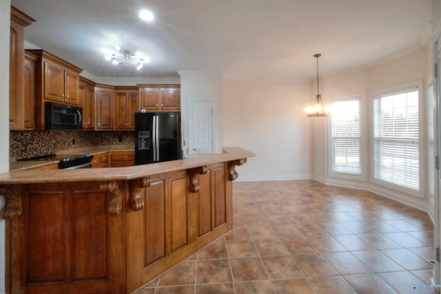 kitchen featuring ornamental molding, black appliances, an inviting chandelier, and tasteful backsplash