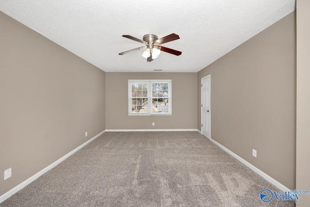 carpeted empty room with ceiling fan and a textured ceiling