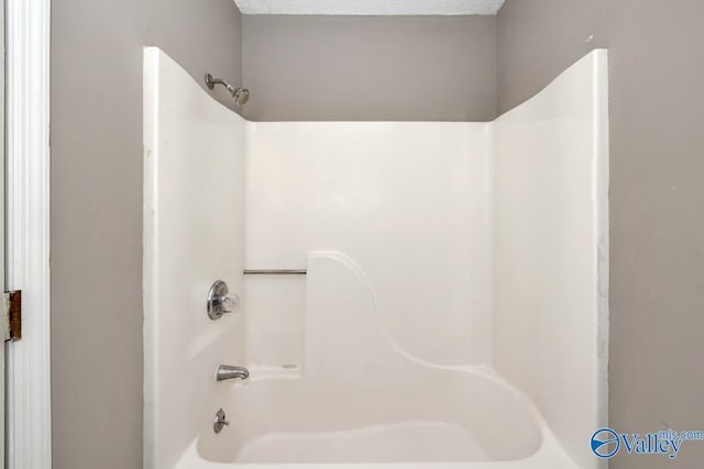 bathroom featuring bathing tub / shower combination and a textured ceiling