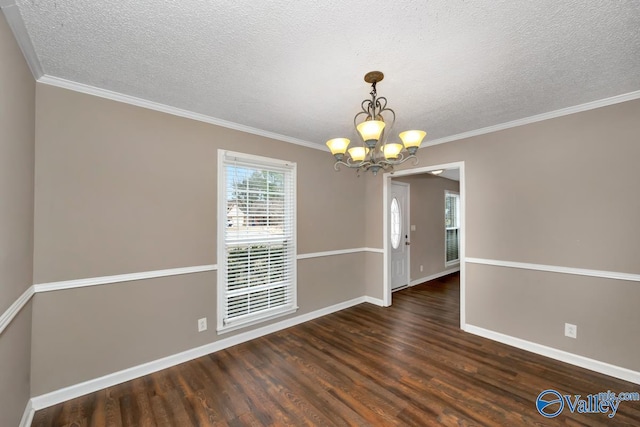 unfurnished room with dark hardwood / wood-style flooring, a textured ceiling, ornamental molding, and a chandelier