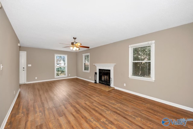 unfurnished living room featuring dark hardwood / wood-style flooring and ceiling fan