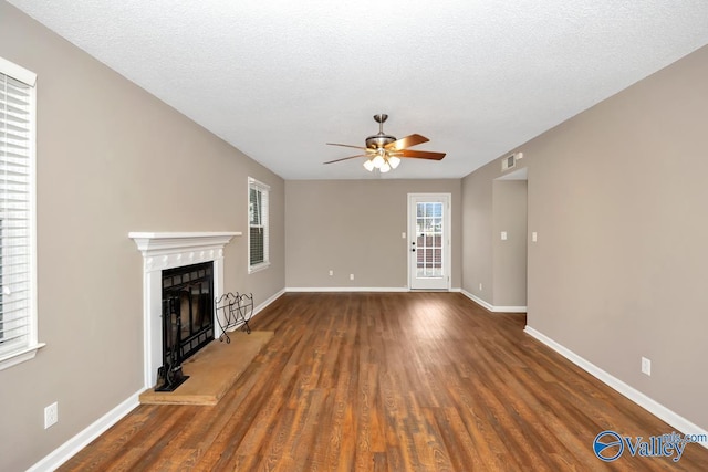 unfurnished living room featuring a textured ceiling, dark wood-type flooring, and ceiling fan