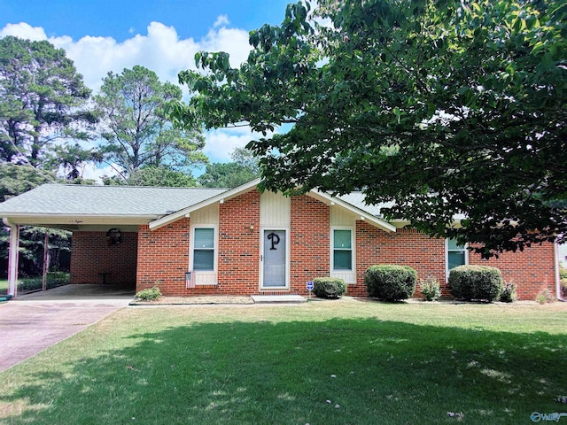 view of front of house featuring a shingled roof, brick siding, driveway, a carport, and a front lawn