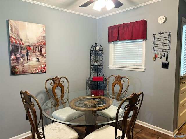 tiled dining area featuring crown molding, baseboards, and a ceiling fan