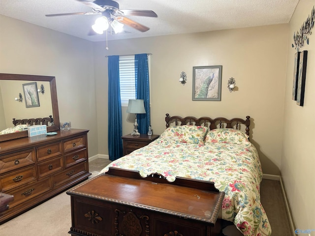 bedroom with light carpet, a ceiling fan, baseboards, and a textured ceiling