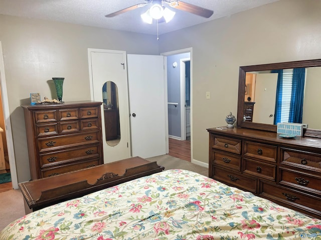 bedroom with a textured ceiling, a ceiling fan, and light colored carpet