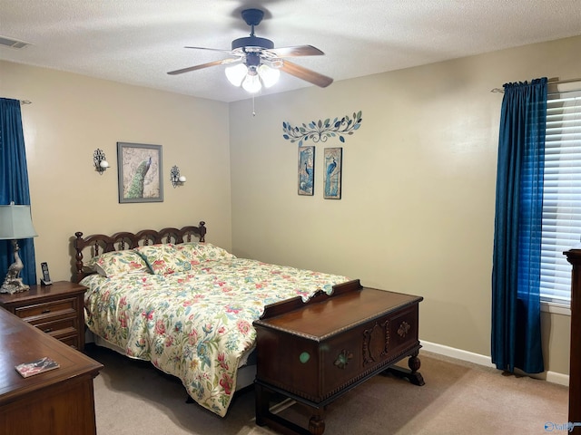 carpeted bedroom with visible vents, ceiling fan, a textured ceiling, and baseboards