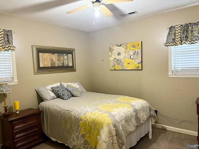 bedroom with baseboards, visible vents, ceiling fan, a textured ceiling, and carpet floors