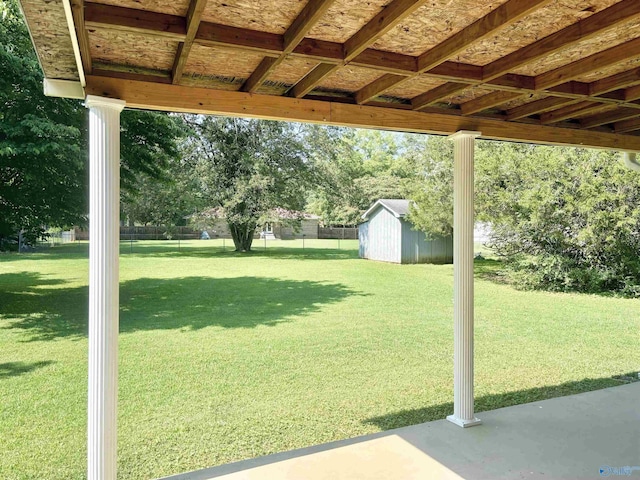 view of yard with an outbuilding, a storage unit, and fence