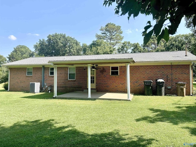 rear view of property with a patio, ceiling fan, a yard, central AC, and brick siding