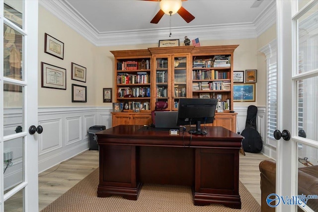 home office featuring french doors, wainscoting, a ceiling fan, and crown molding