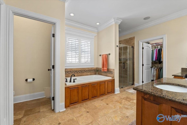 full bathroom with a stall shower, a garden tub, a walk in closet, crown molding, and vanity