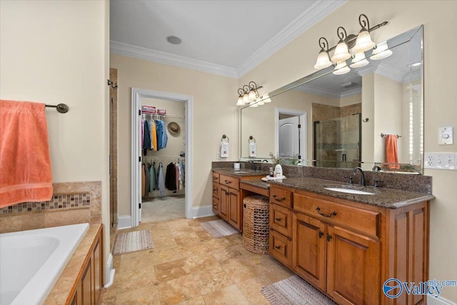 full bath with a garden tub, a spacious closet, ornamental molding, a stall shower, and a sink