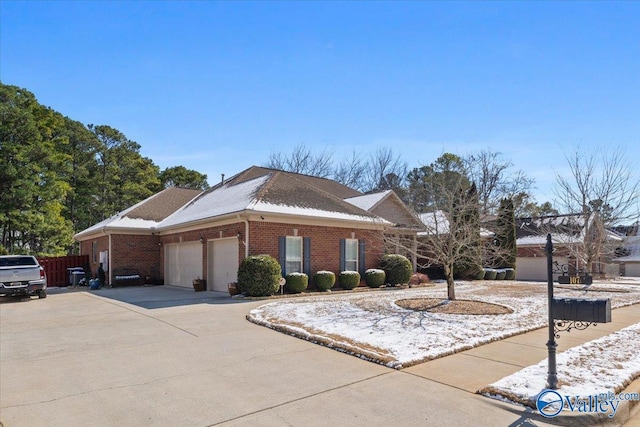 view of side of property with driveway, brick siding, and an attached garage