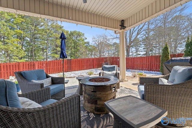 view of patio with a fenced backyard and an outdoor living space with a fire pit