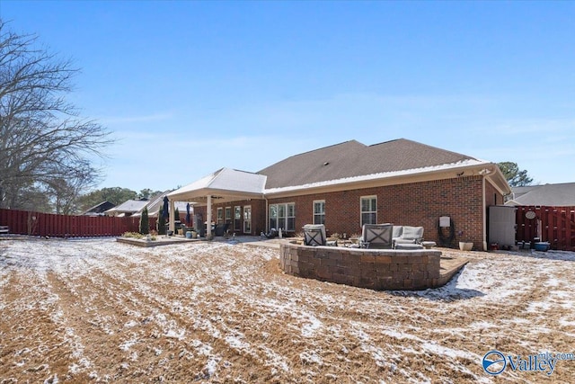 rear view of house featuring a fire pit, a patio area, fence, and brick siding