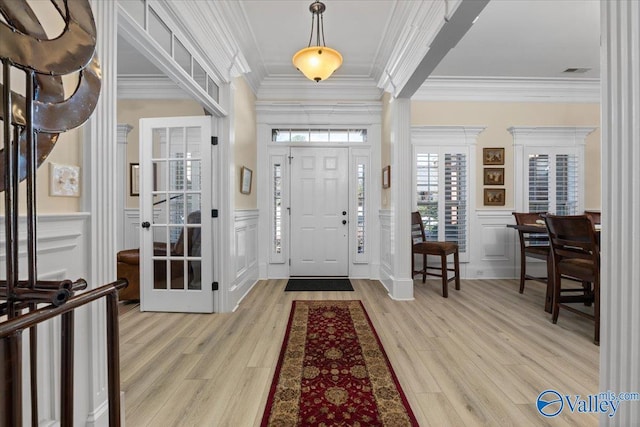 entryway featuring ornamental molding, light wood-type flooring, and visible vents